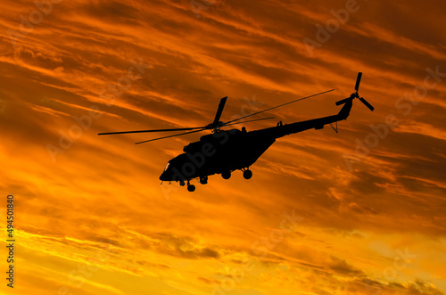 Silhouette of Helicopter on sunset background. © Andrii Salivon
