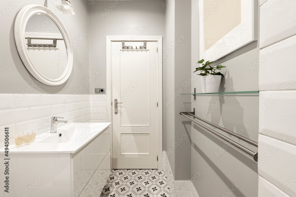 Toilet with white porcelain sink on wooden cabinet, stainless steel towel rail and glass shelf Toilet with white porcelain sink on wooden cabinet, stainless steel towel rail and glass shelf