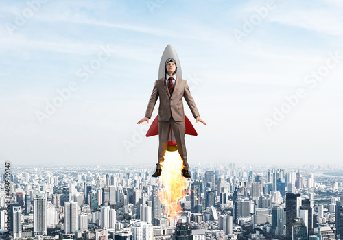Foto Businessman in aviator hat flying on rocket