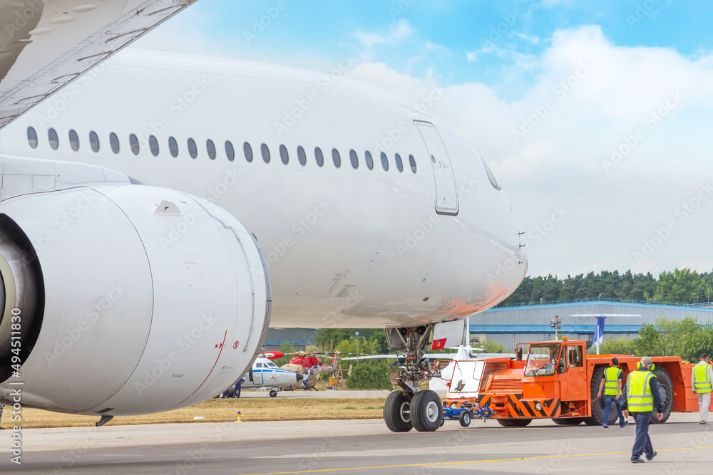 Pushback truck is towing the aircraft to a parking lot Pushback truck is towing the aircraft to a parking lot