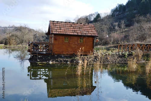 an old small wooden house on the lake and a reflection