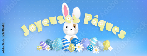 Texte jaune «Joyeuses Pâques» et un mignon lapin blanc derrière des oeufs colorés et des fleurs sur un fond bleu