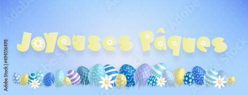 Texte jaune «Joyeuses Pâques» avec de jolies oeufs colorés et des fleurs alignés sur un fond bleu