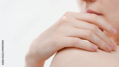 Big close-up shot of female hand lays on shoulder against white background   Skin brightening concept