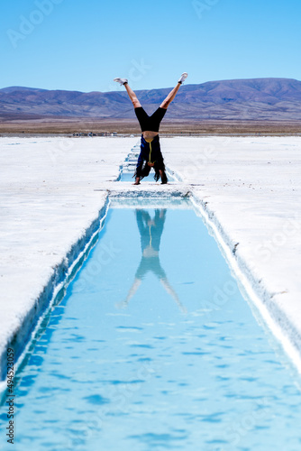 Vertical shot of a female doing a handstand at the Salinas Grandes in Argentina photo