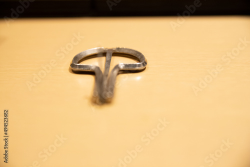 Closeup of a small metal jaw harp on a wooden surface photo
