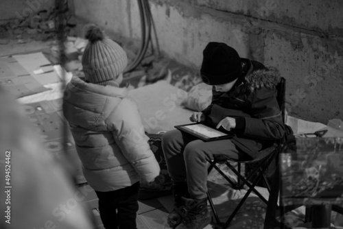 The war between Russia and Ukraine. Children sit in the bomb shelter. Air alarm. photo