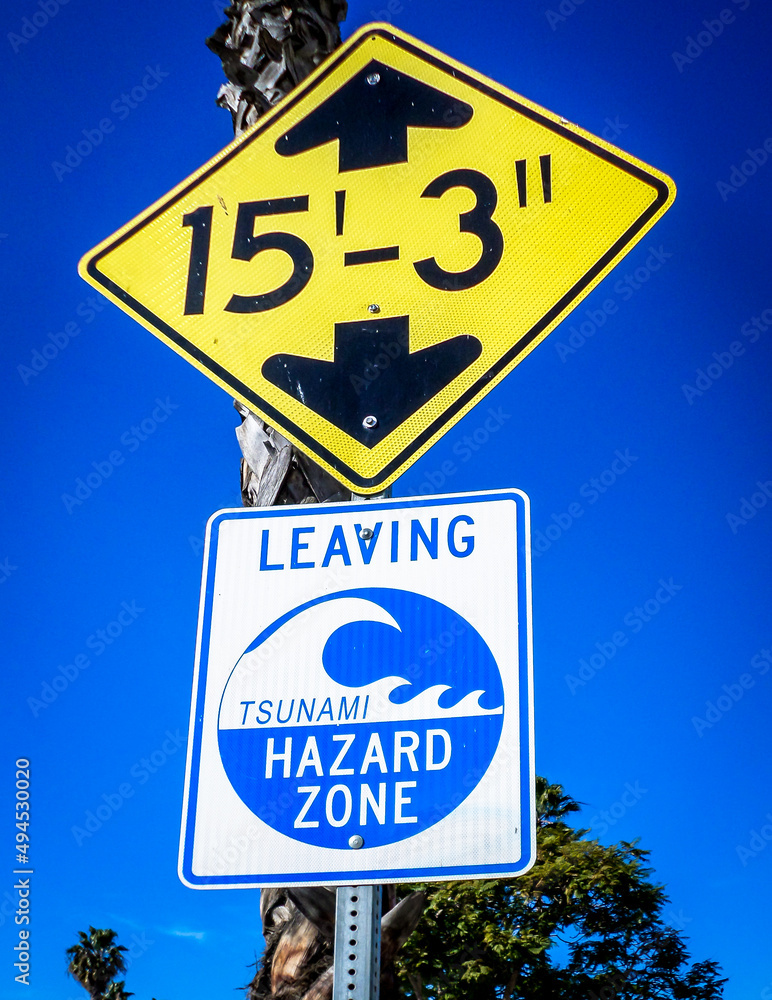 View of a road sign and a warning sign of tsunami in a street of Santa Barbara, USA
