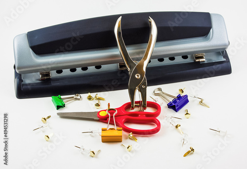 Closeup shot of desktop hole puncher, paper clips, and scissors isolated on white background photo