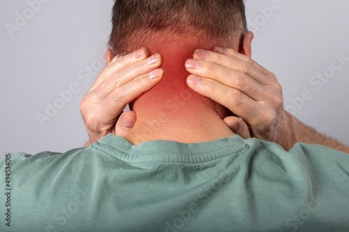 Nape pain closeup. Ache in back neck. Abstarct man suffering from injury, strain, discomfort.