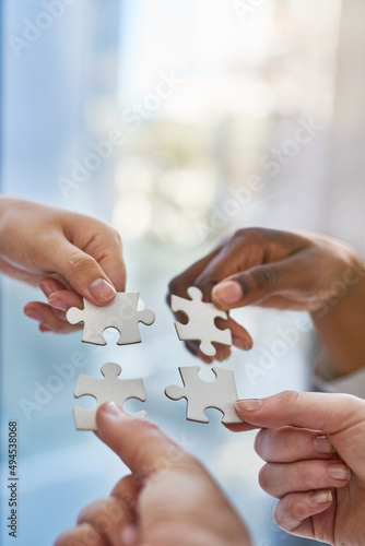 Joining together as a team. Shot of hands putting puzzle pieces together.