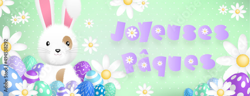 Texte mauve «Joyeuses Pâques», avec un mignon lapin blanc derriere des oeufs colorés et des fleurs sur un fond vert