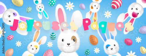 Texte «Joyeuses Pâques» aux couleurs pastels et de nombreux lapins dispersés autour accompagnés d’oeufs colorés et de fleurs sur un fond bleu