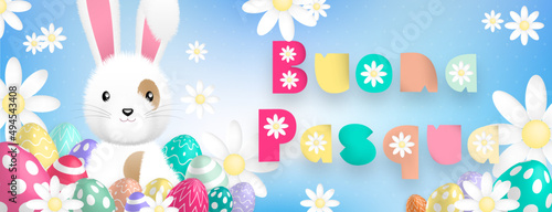 Italian text with sweet colors : Buona Pasqua, with a cute white rabbit behind colored eggs and flowers on a blue background