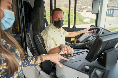 male driver selling a bus ticket to a female passenger
