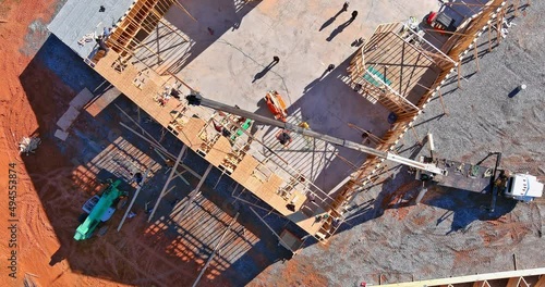 Crane holds timber roof frame of wooden rafters beams an interior view house building on arerial viewed photo