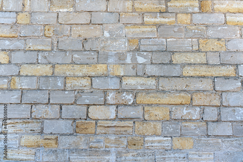 Fototapeta premium Old brick wall made of limestone stones of different sizes as a natural background