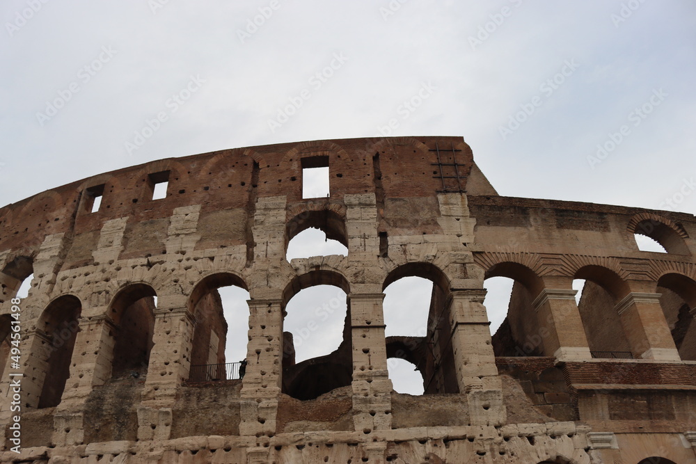 ROME, ITALY - February 05, 2022: Panoramic view of inside part of Colosseum in city of Rome, Italy. Cold and gray sky in the background. Macro photography of the arches.