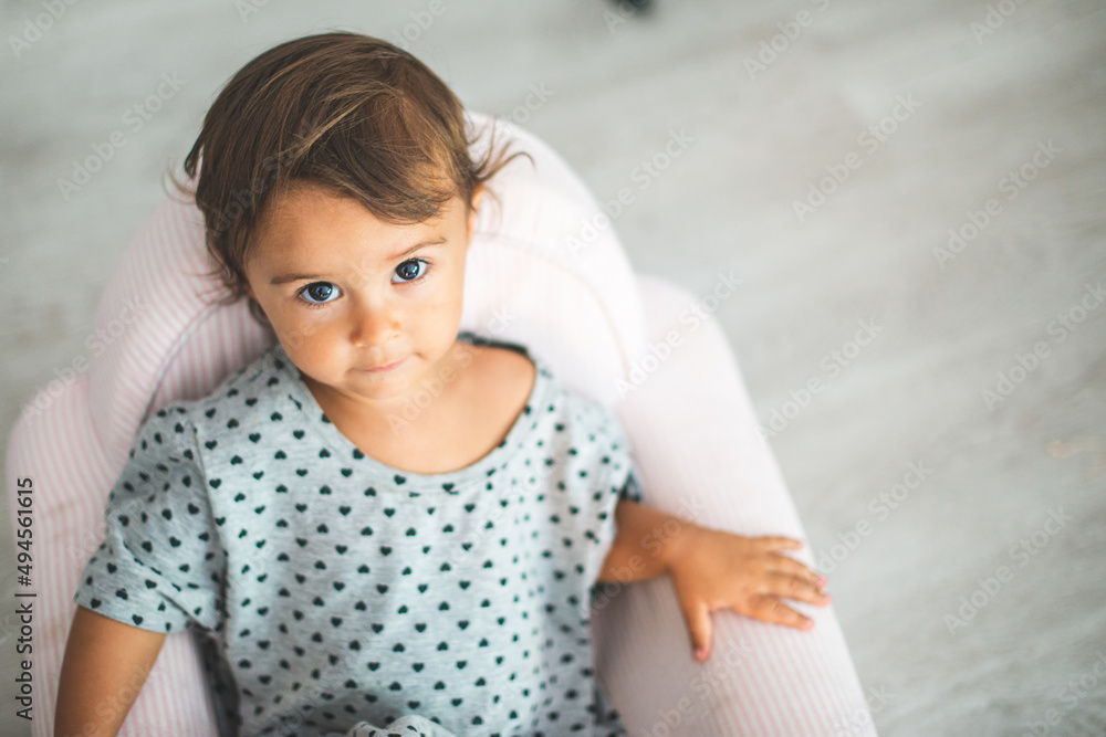 Cute little girl sitting on small armchair and smiling at camera. Cute little girl sitting on small armchair and smiling at camera.