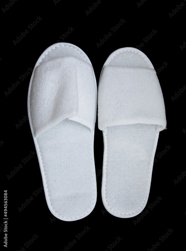 White disposable slippers on a black background. White disposable slippers on a black background.