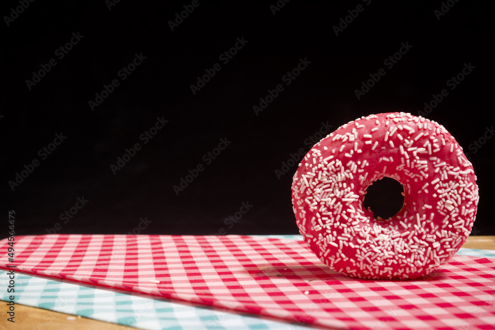 Closeup of a glazed fresh donut on chequered tablecloths on a cutting board  Stock Photo | Adobe Stock