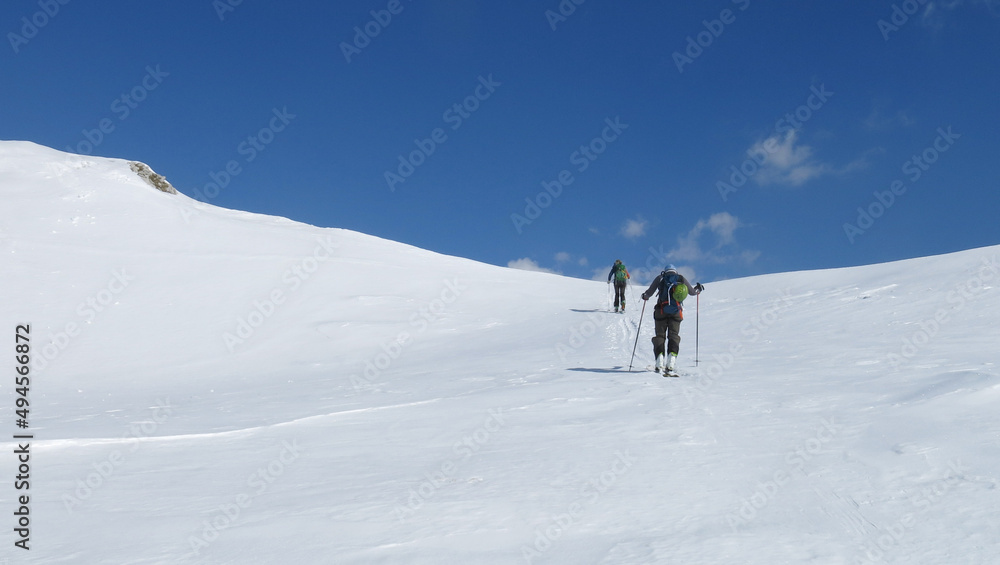  Two man climbing up with tour ski. White landscape, blue sky. Fresh day. Slovenia, Julian Alps, Triglav national park, Komna     