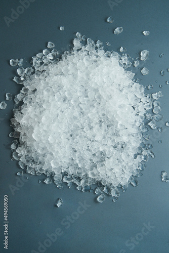 Pile of crushed ice cubes on black blue background, top view with copy space