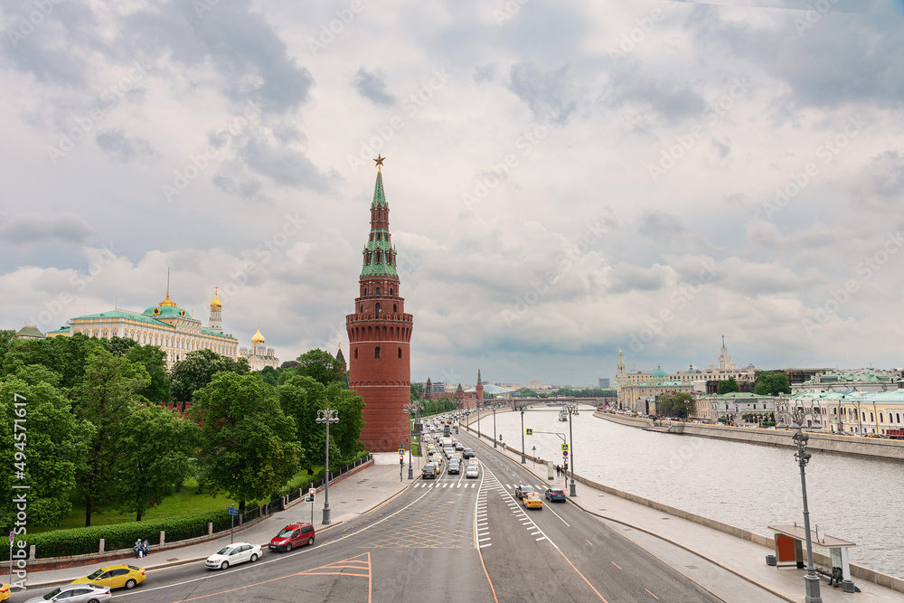 Embankment of the Moscow River with many cars. The towers of the Moscow Kremlin against the background of a cloudy spring sky Embankment of the Moscow River with many cars. The towers of the Moscow Kremlin against the background of a cloudy spring sky