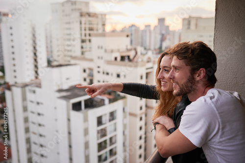 Take in the sights and you might find wonder. Cropped shot of an attractive young couple on a rooftop looking over the city.