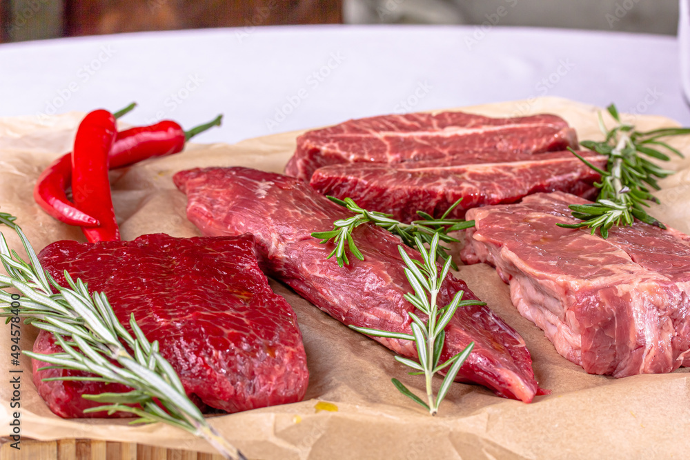 Rib Eye Steak, Striploin Steak, Butterfly Steak made of marble raw beef lie on the board Rib Eye Steak, Striploin Steak, Butterfly Steak made of marble raw beef lie on the board