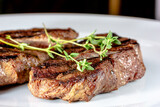 Grilled marbled beef steak lies on a white plate