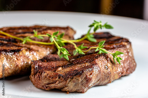 Grilled marbled beef steak lies on a white plate
