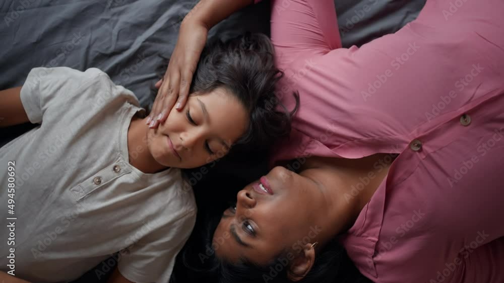 Overhead view of indian mother lying on bed with her little son at home. Overhead view of indian mother lying on bed with her little son at home.