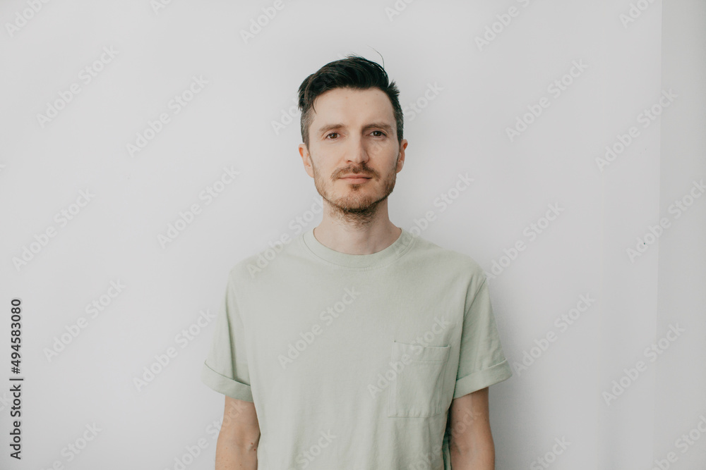 Handsome young man over grey wall with serious expression on face. Simple natural looking at camera. Handsome young man over grey wall with serious expression on face. Simple natural looking at camera.