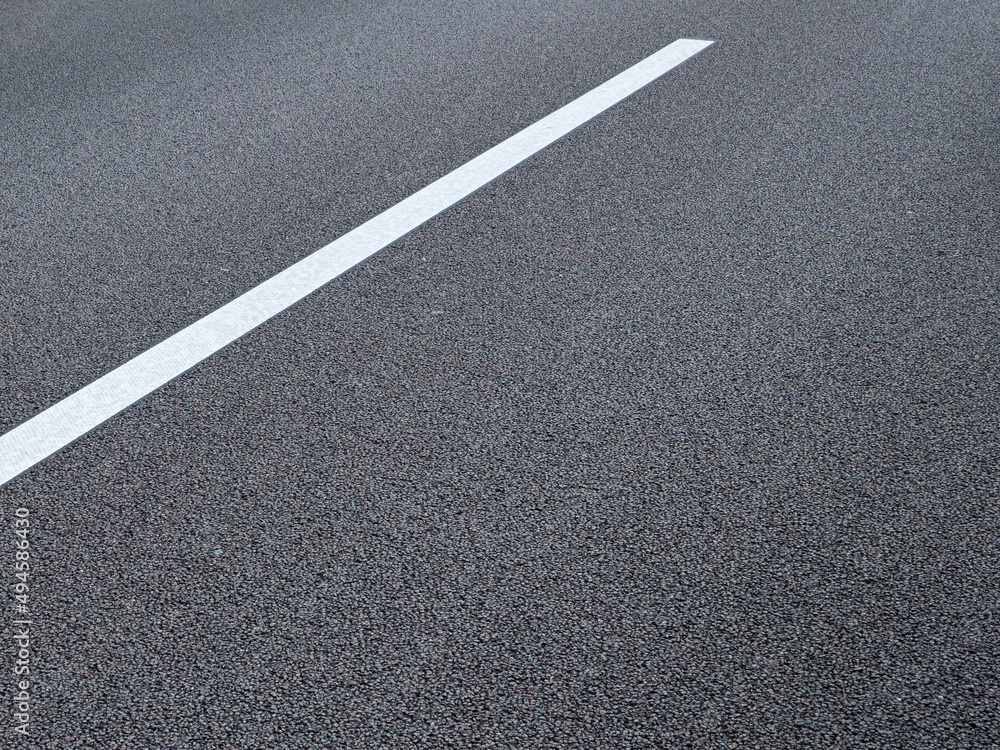 The lane marking on a German autobahn appears as an abstract graphic in the close-up. 