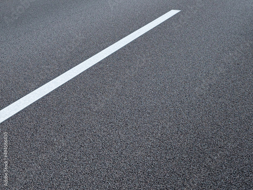 The lane marking on a German autobahn appears as an abstract graphic in the close-up. 