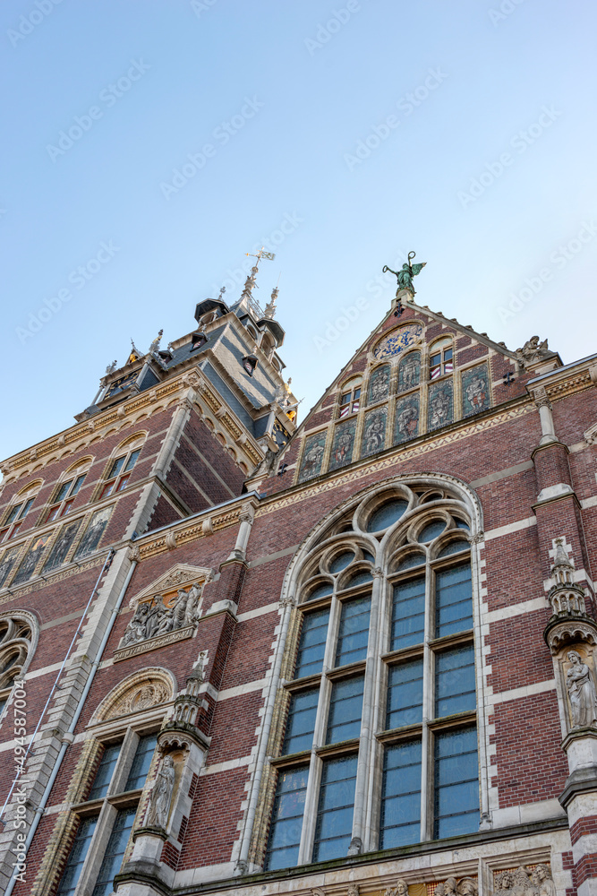 Fragment of an old church in Amsterdam with stained glass windows against the blue sky