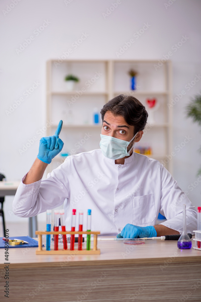 Young male chemist working at the lab Young male chemist working at the lab