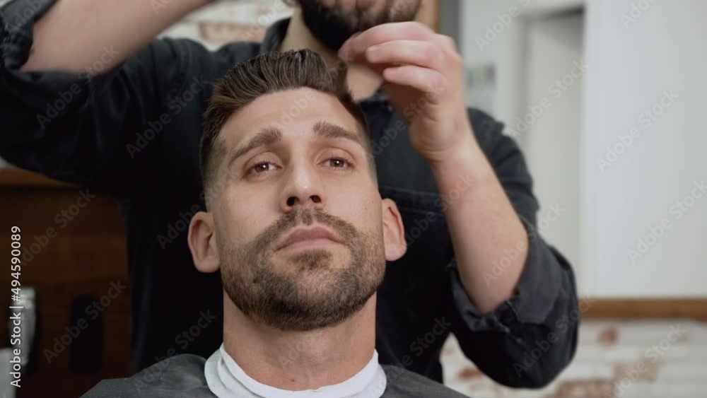 Barber shop. Man in barber's chair, hairdresser styling his hair. High quality 4k footage Barber shop. Man in barber's chair, hairdresser styling his hair. High quality 4k footage