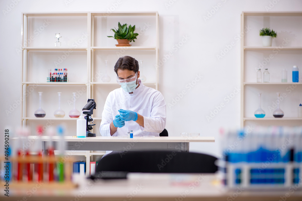 Young male chemist working at the lab Young male chemist working at the lab