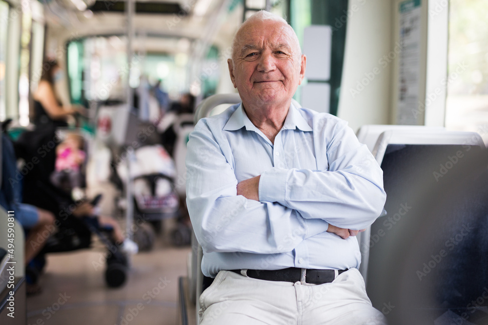 Elderly Caucasian man sitting in tram and looking in camera. - obrazy, fototapety, plakaty 