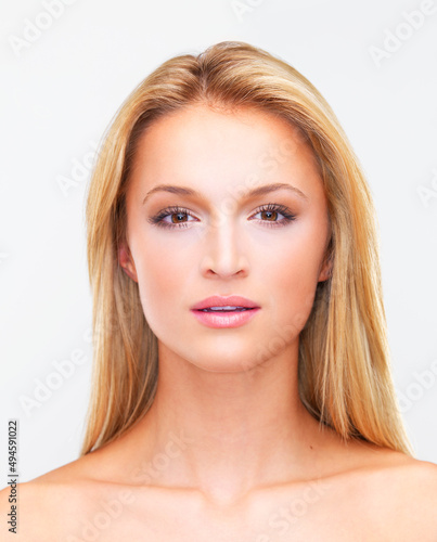 Realise total perfection. Portrait of a beautiful blonde woman with flawless skin gazing at you, isolated on white.