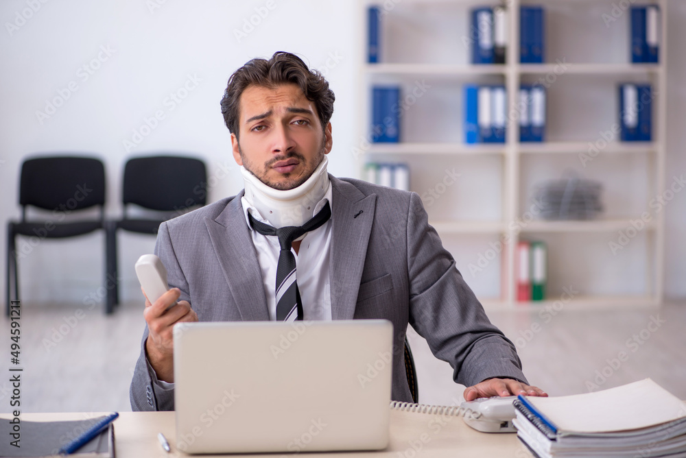 Fototapeta premium Young male employee after car accident working in the office