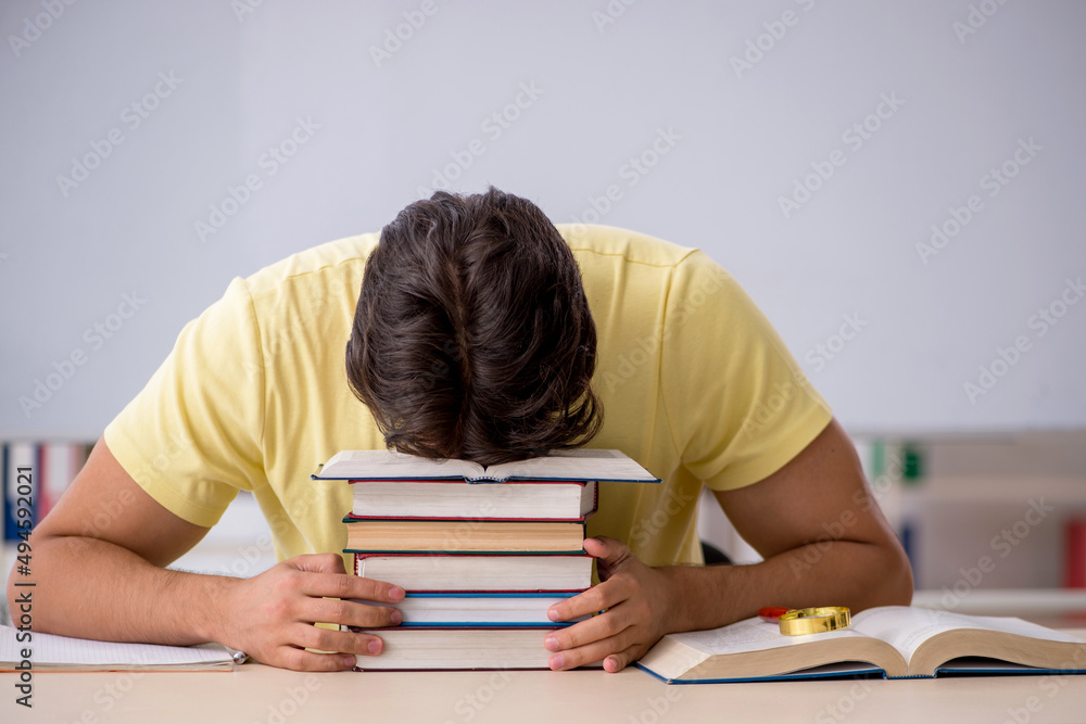Young male student preparing for exams in the classroom Young male student preparing for exams in the classroom