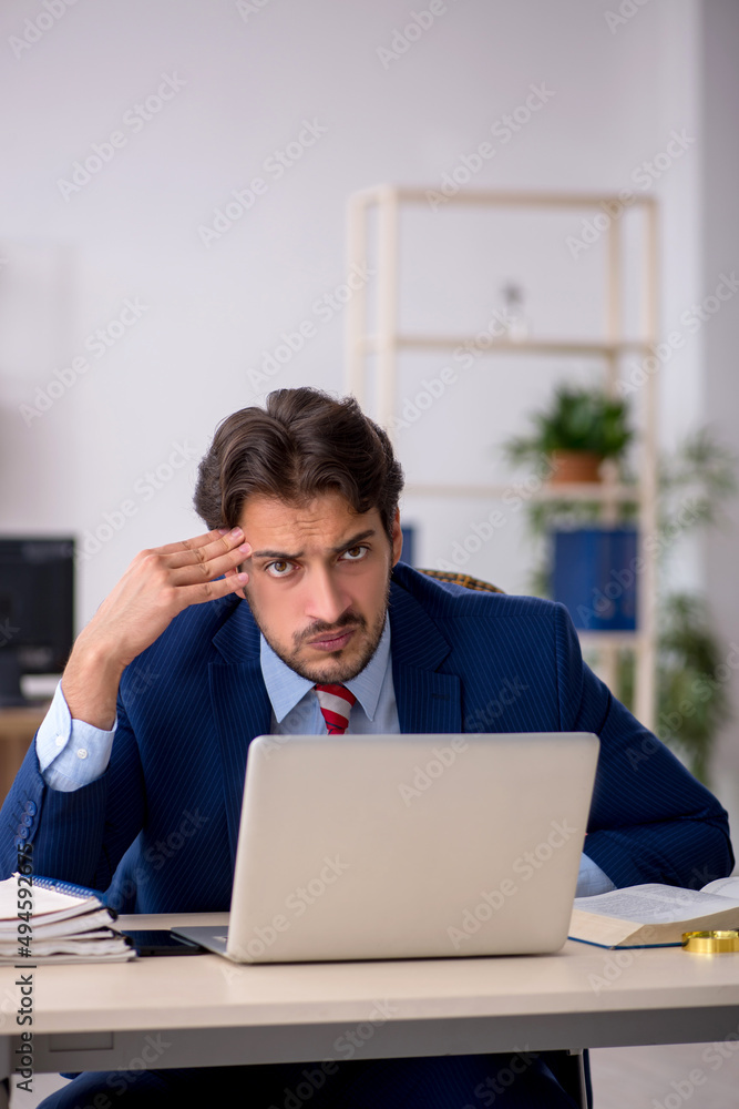 Young male employee working in the office Young male employee working in the office