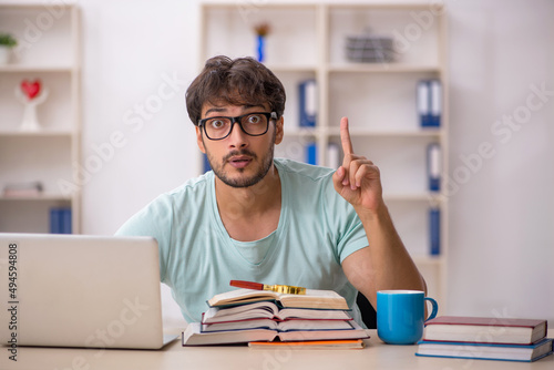 Young male student preparing for exams in the classroom