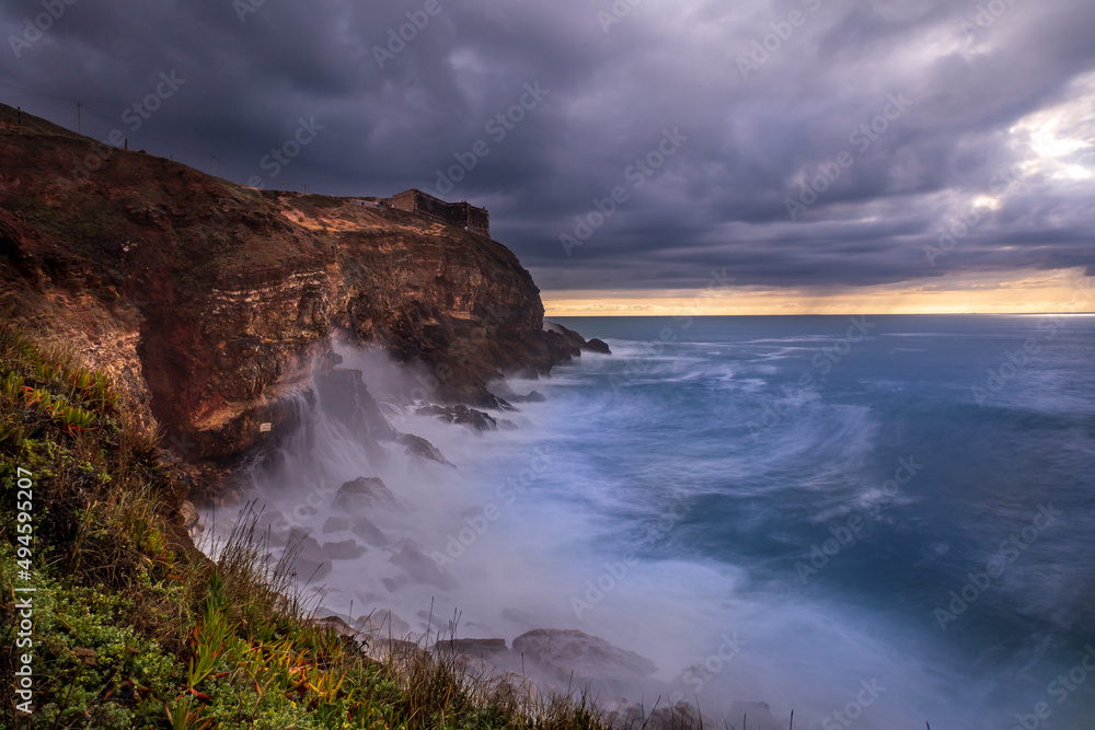 Seascape view of the big waves in the Nazare canyon. Big waves splashing against the rocks at Praia do Norte, Nazare - Portugal Seascape view of the big waves in the Nazare canyon. Big waves splashing against the rocks at Praia do Norte, Nazare - Portugal