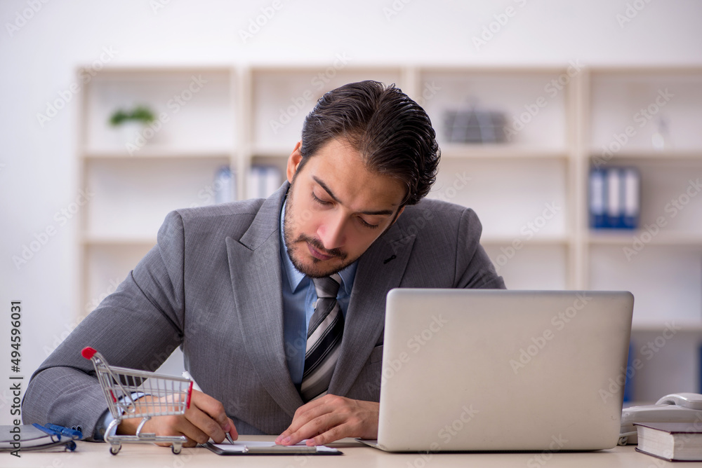 Young male employee in e-commerce concept Young male employee in e-commerce concept
