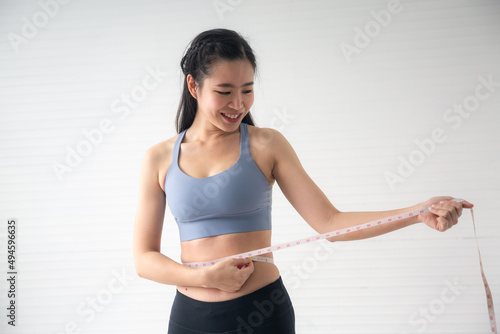 Fototapeta Naklejka Na Ścianę i Meble -  young Asian woman measure body proportions, health fitness to slim body concept