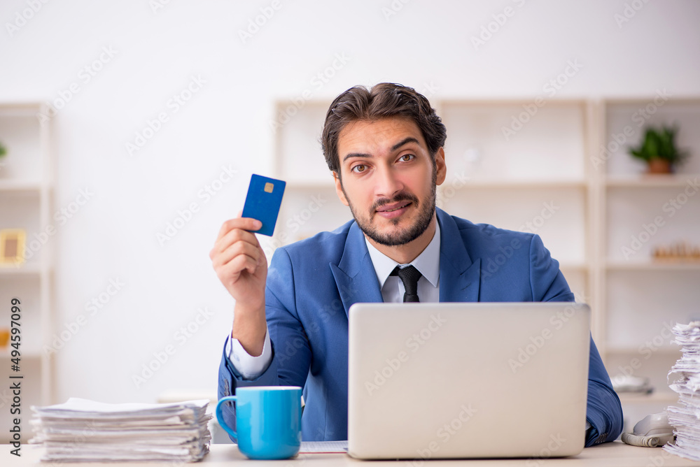 Young male employee and too much work in the office Young male employee and too much work in the office